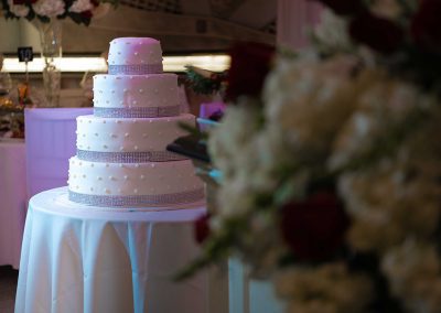 a wedding cake on a table, with flowers